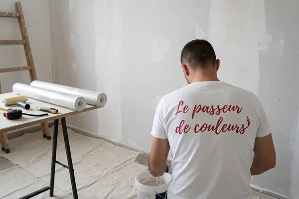 Le passeur de couleurs en train enduire un mur Le passeur de couleurs en train d'enduire un mur
